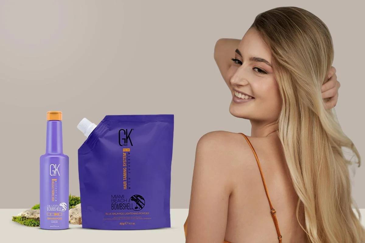 A sleek bottle and pouch of GK hair products are displayed next to a woman with long, wavy hair, showcasing smooth hair texture.