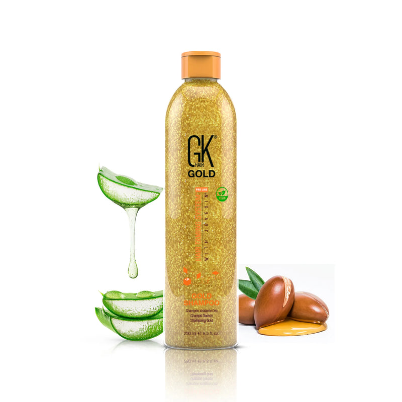GK Hair Gold Shampoo Pro 250 ml gold shimmer bottle beside aloe vera slices and argan nuts on a white background