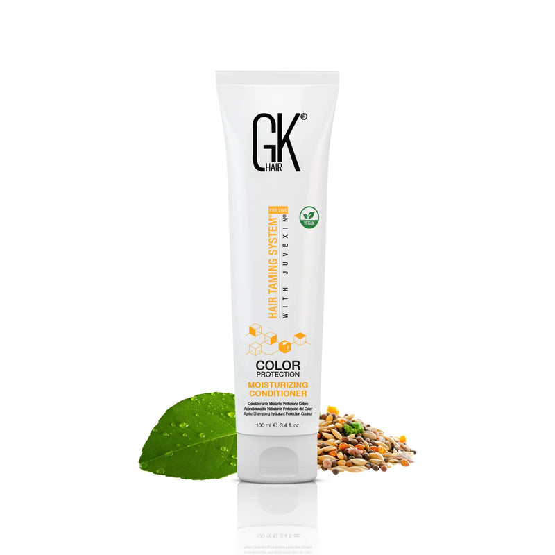 GK Hair Color Protection Moisturizing Conditioner tube, 100 ml / 3.4 fl. oz., beside a dewy green leaf and a pile of seeds