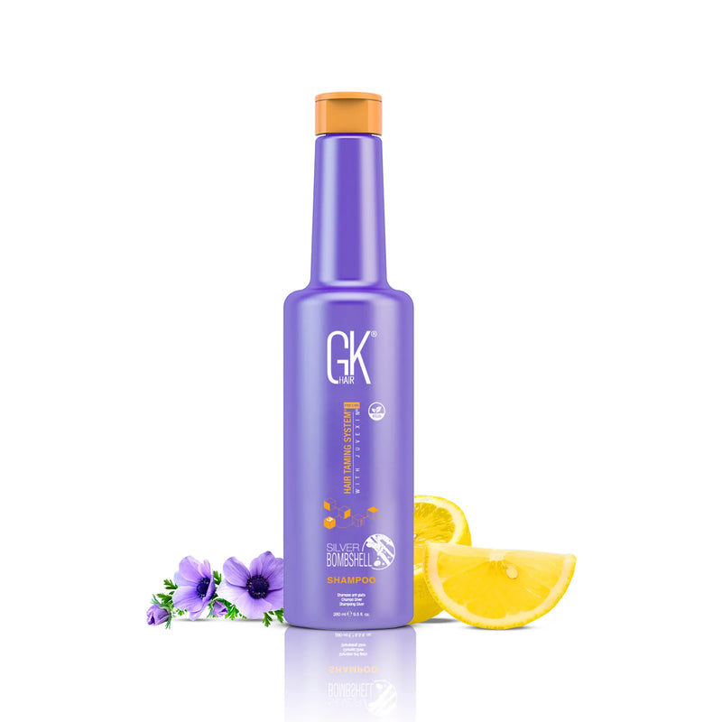 GK Hair Silver Bombshell Shampoo Pro 280 ml purple bottle with orange cap, beside lemon slices and purple anemones